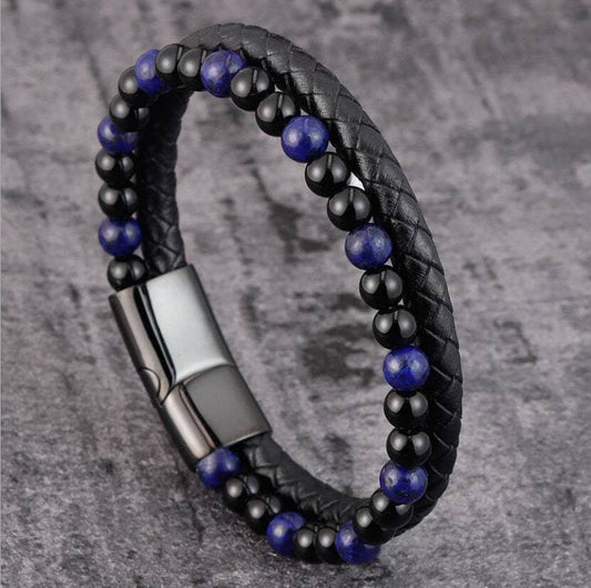 Black braided leather bracelet with blue beads on a gray textured background