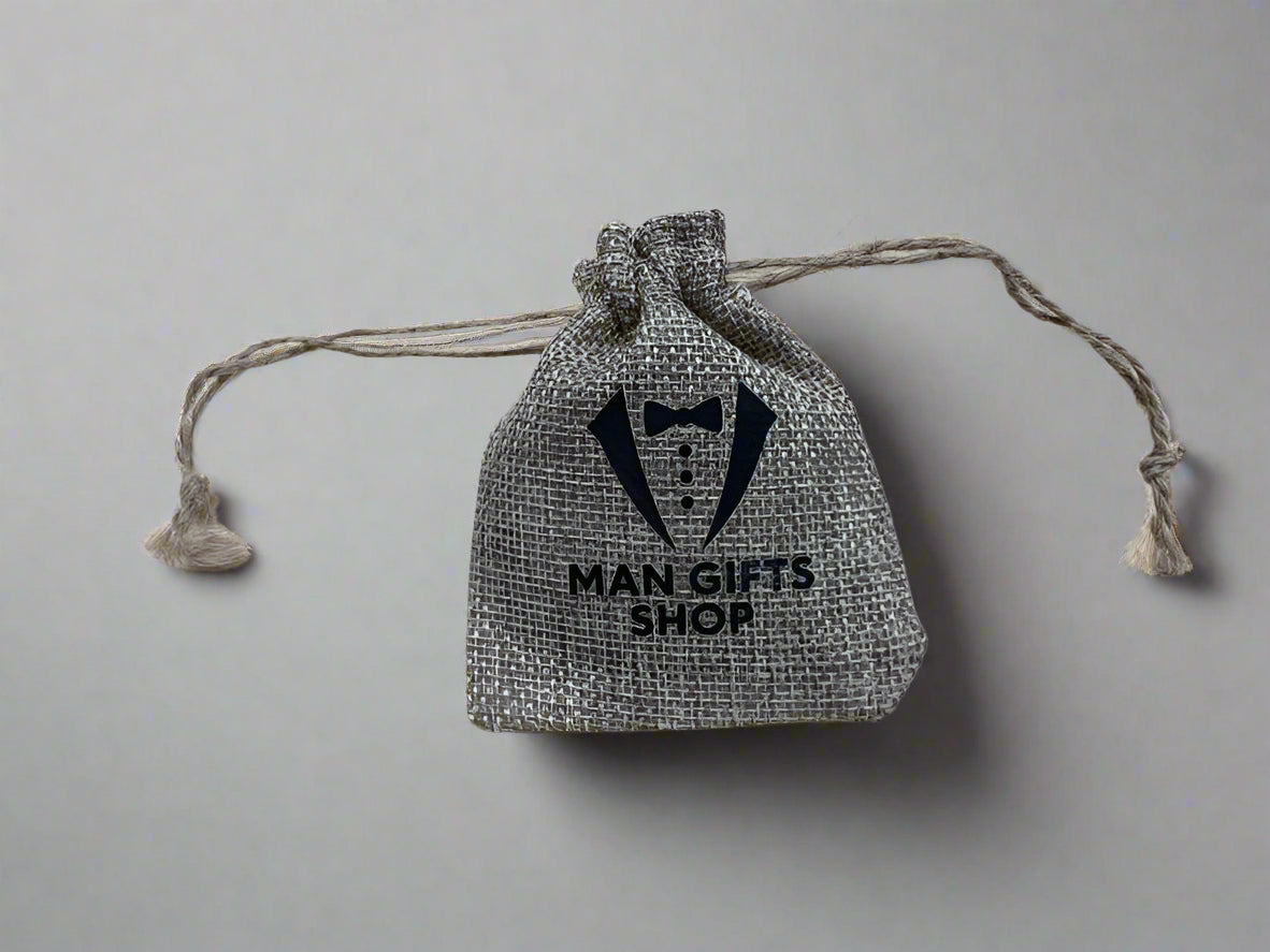 Textile drawstring bag with 'Man Gifts Shop' branding on a wooden surface