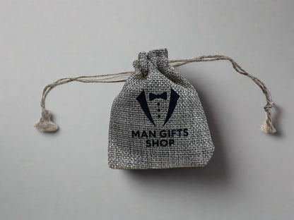 Textile drawstring bag with 'Man Gifts Shop' branding on a wooden surface
