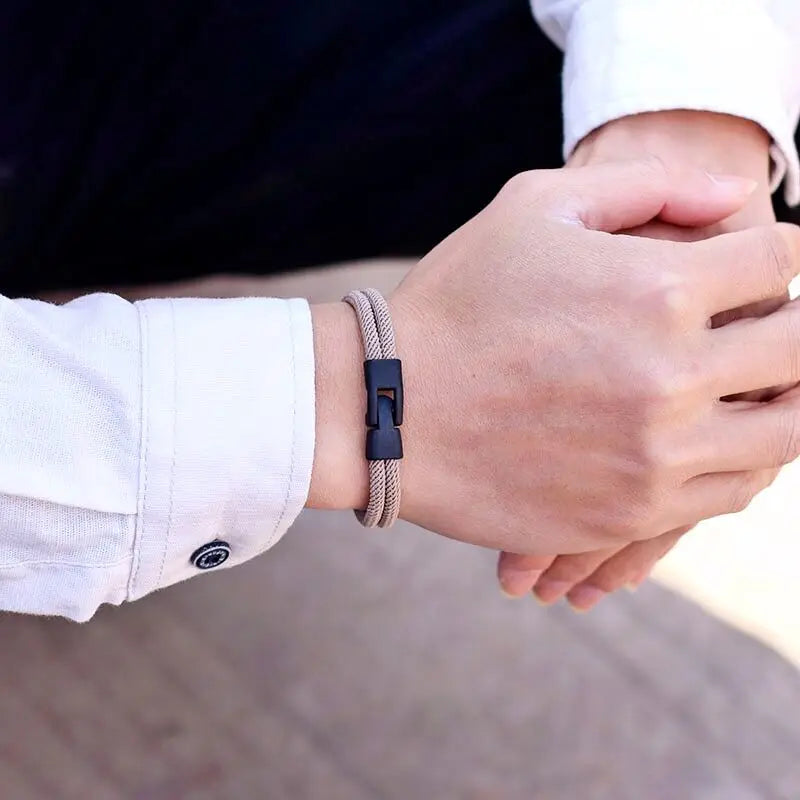 One man's hands with matching bracelets on a blurred background