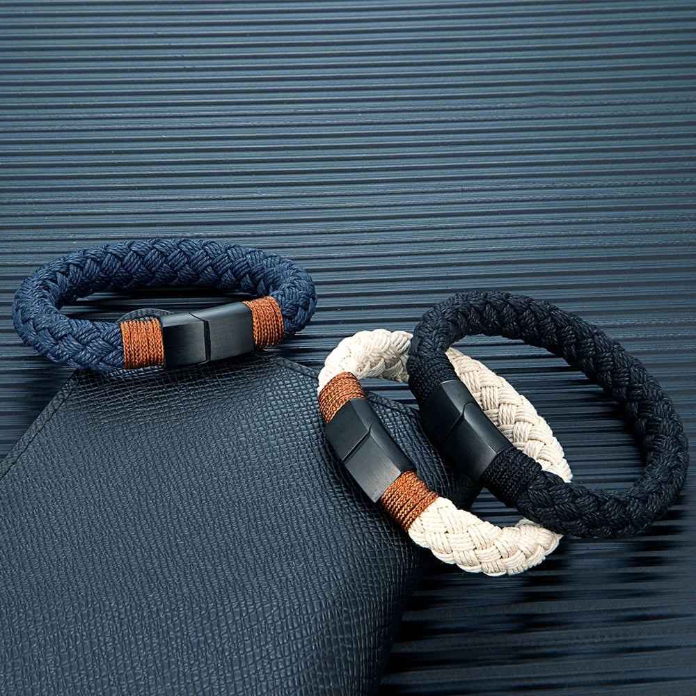 Three braided bracelets with black metal clasps on a textured blue background