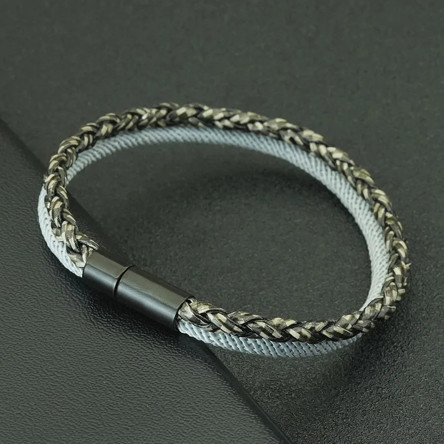 Bracelet with braided design and metallic clasp on a dark surface