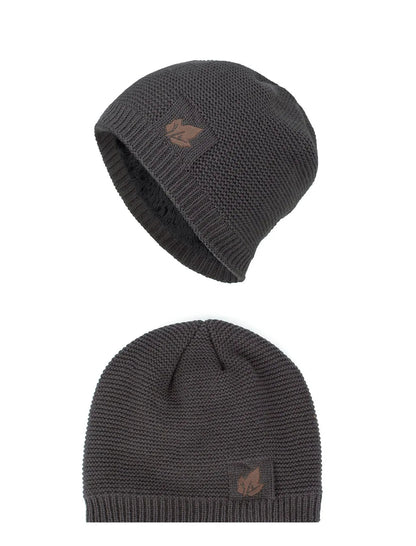 Two dark gray knit beanie hats with a brand logo on a white background