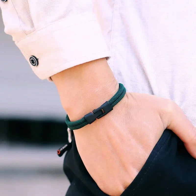 Person wearing a green bracelet on a blurred background